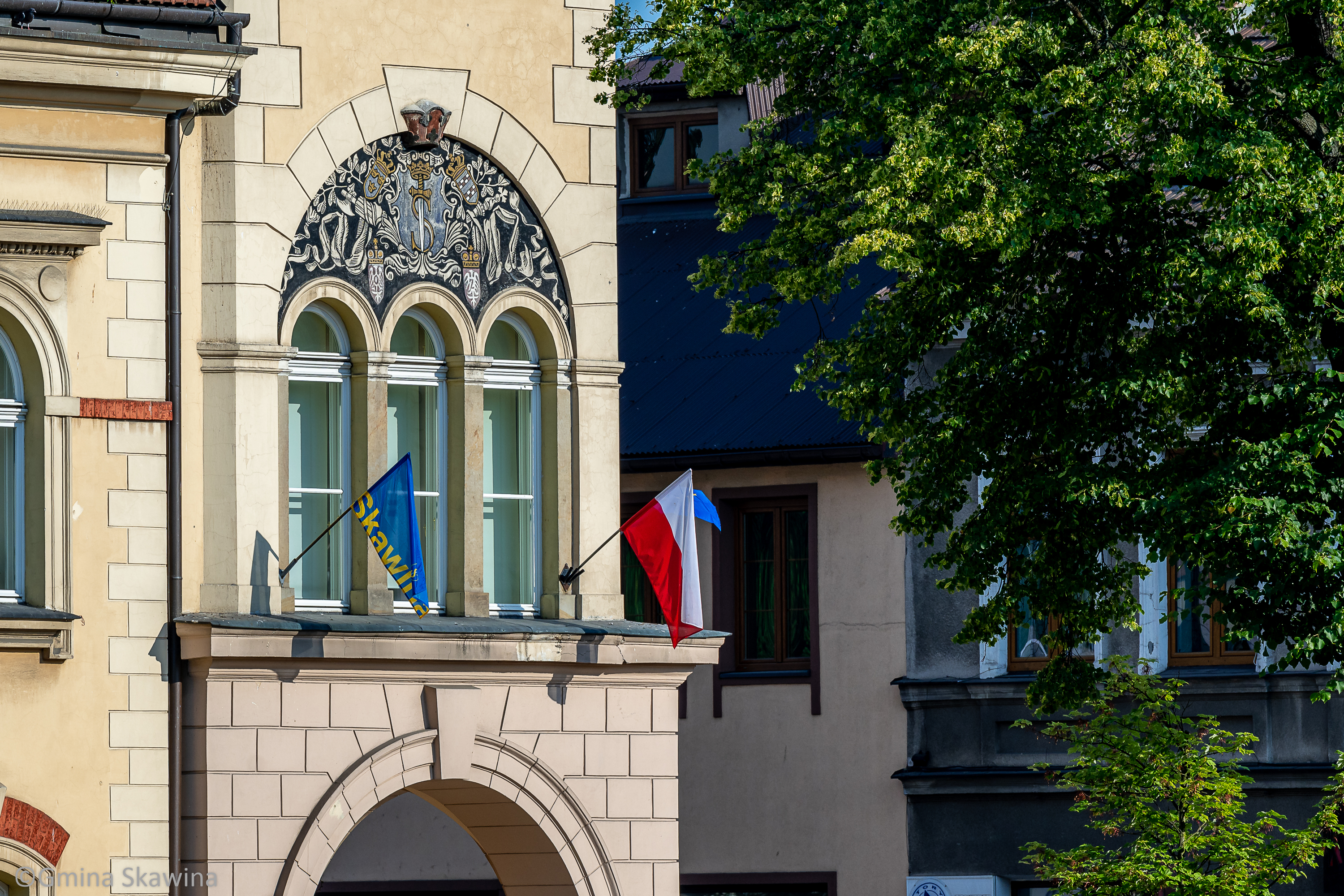zdjęcie ratusza z flagą Skawiny i Polski.