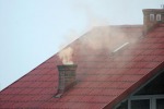 zdjęcie komina z którego wydobywa się dym