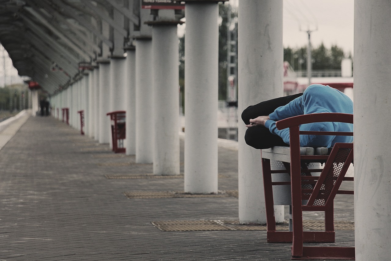 śpiący bezdomny na ławce 