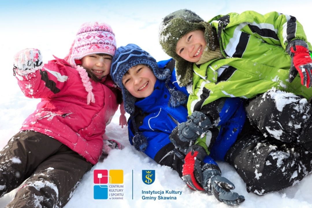 uśmiechnięte dzieci w strojach zimowych, bawiące się na śniegu.