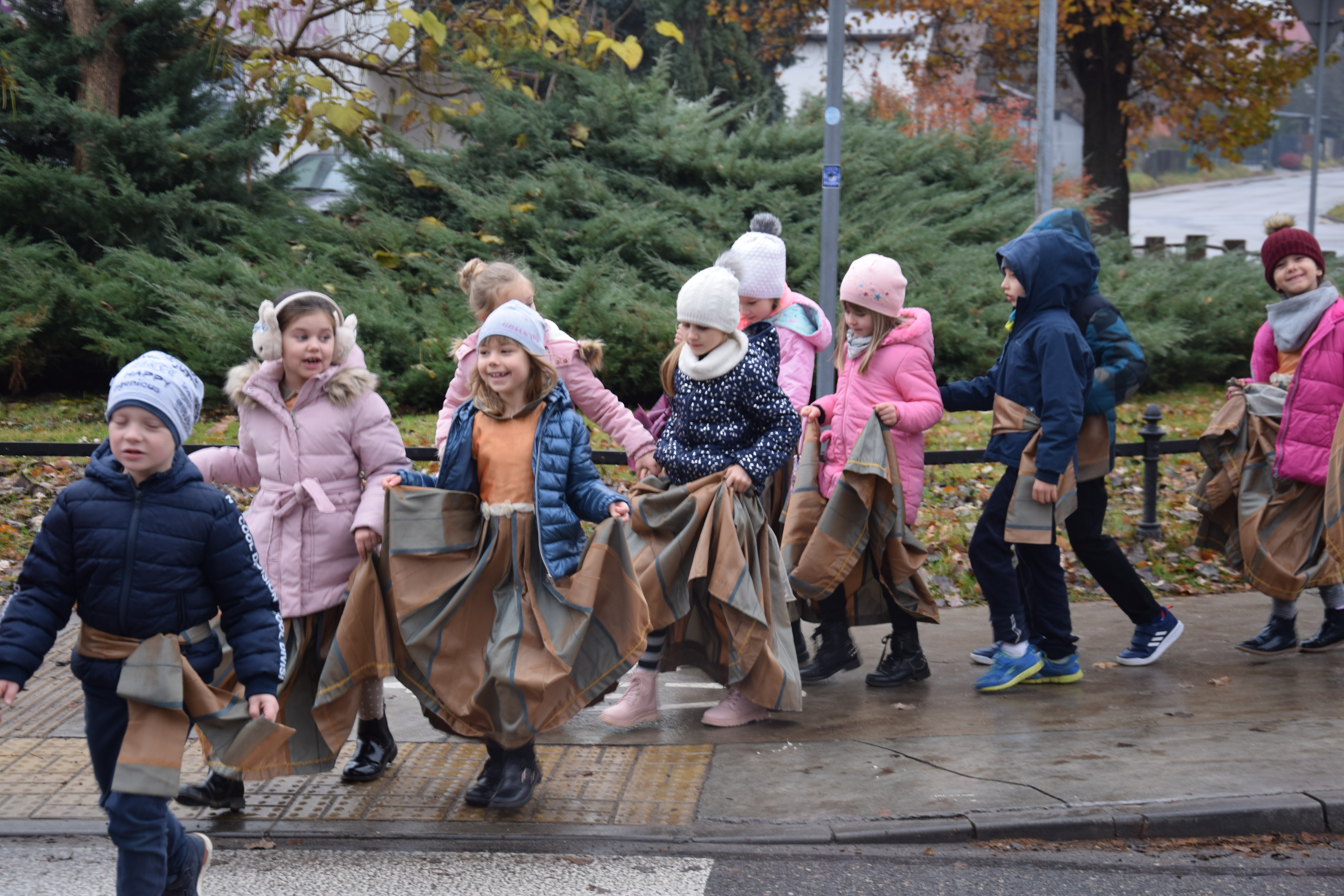 zdjęcie dzieci przechodzących przez pasy, ubrane w starodawne stroje